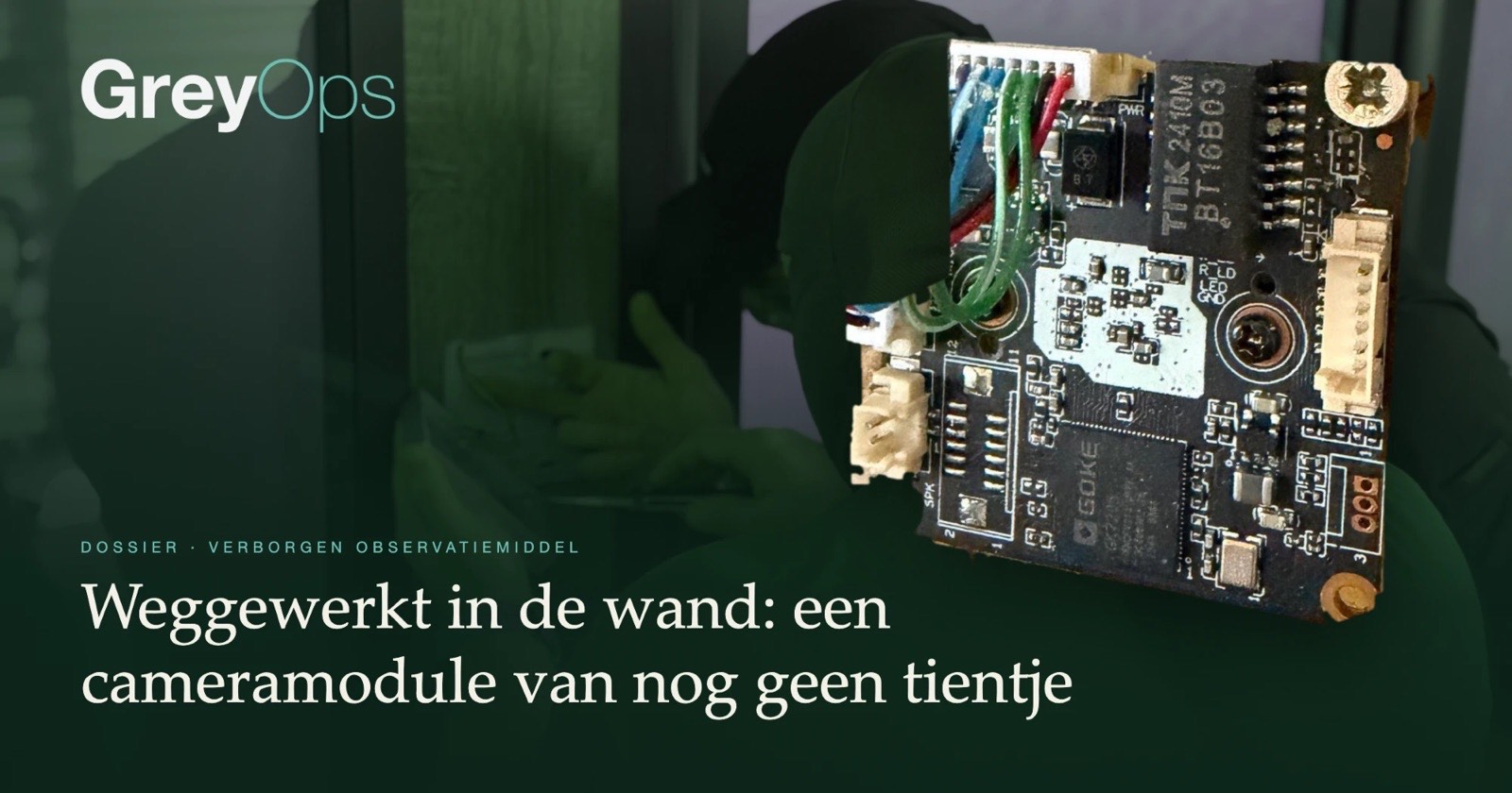 De uit de wand gehaalde cameraprintplaat, met op de achtergrond onderzoekers in het kantoor